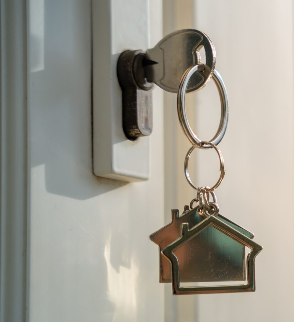 new home door lock with key in the lock attached to house shaped key chain
