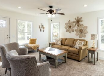 Modular home living room with lots of windows, white walls and modern fixtures and furniture.
